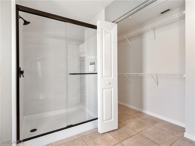 bathroom featuring tile patterned floors and a shower with shower door