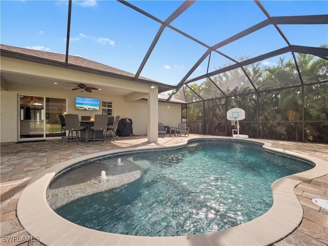 view of swimming pool featuring ceiling fan, a lanai, pool water feature, and a patio