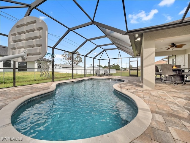 view of pool featuring ceiling fan, a patio area, and glass enclosure