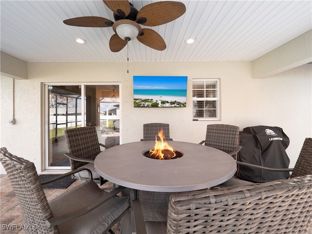 view of patio / terrace featuring ceiling fan, grilling area, and a fire pit