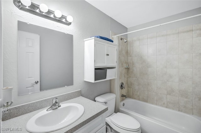 full bathroom with vanity, tiled shower / bath, and toilet