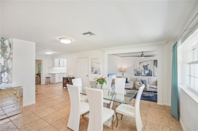 tiled dining space with ceiling fan