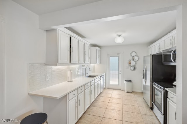 kitchen featuring white cabinetry, appliances with stainless steel finishes, sink, and light tile patterned floors