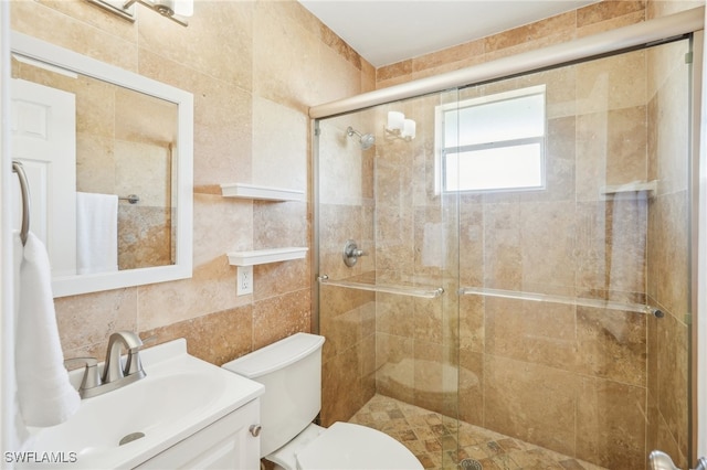 bathroom featuring toilet, tile walls, vanity, backsplash, and a shower with shower door