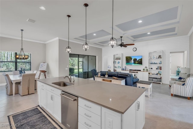 kitchen with pendant lighting, white cabinetry, sink, and a kitchen island with sink