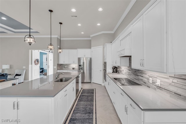 kitchen with white cabinets, sink, hanging light fixtures, appliances with stainless steel finishes, and a large island