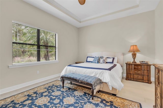 bedroom featuring a raised ceiling and ceiling fan