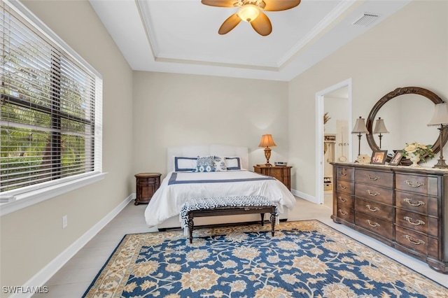 bedroom featuring ceiling fan, ornamental molding, and a tray ceiling