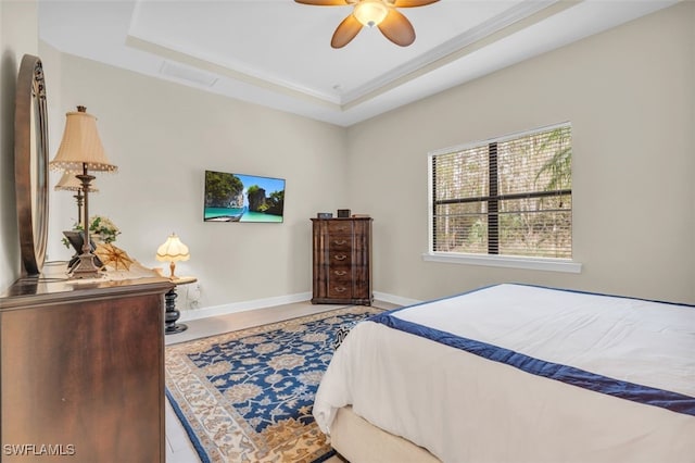 bedroom featuring a raised ceiling and ceiling fan