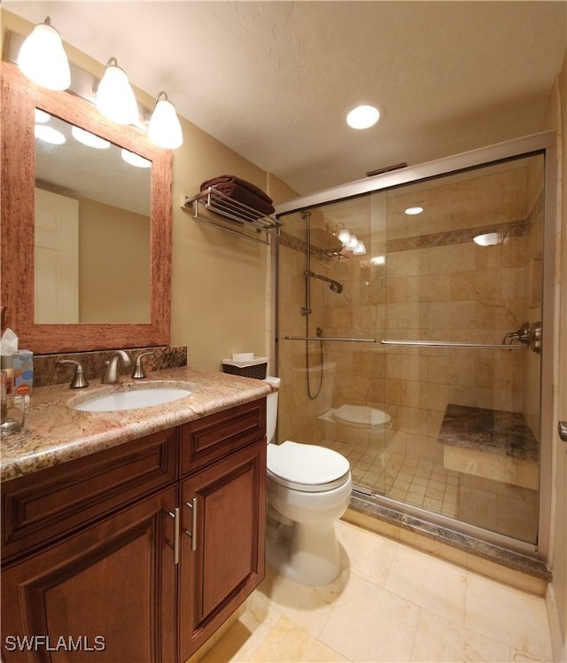 bathroom featuring an enclosed shower, vanity, tile patterned floors, and toilet