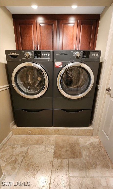 washroom featuring washer and clothes dryer and cabinets