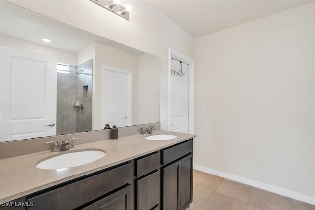 bathroom with vanity, tile patterned flooring, and a tile shower