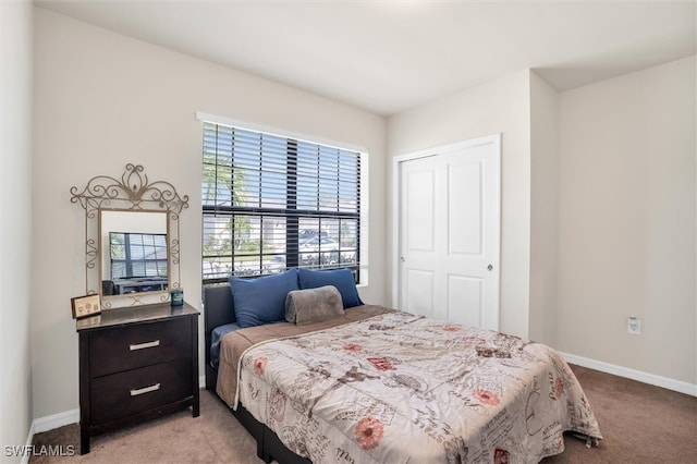 bedroom featuring a closet and light colored carpet