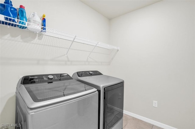 10852 Marlberry Way N, Fort Myers, FL 33917 - laundry room featuring washer and clothes dryer, baseboards, and light tile patterned floors