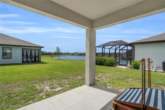 view of yard with a patio area, a water view, and a lanai