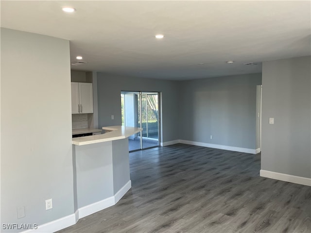 kitchen featuring white cabinets, dark hardwood / wood-style floors, and tasteful backsplash