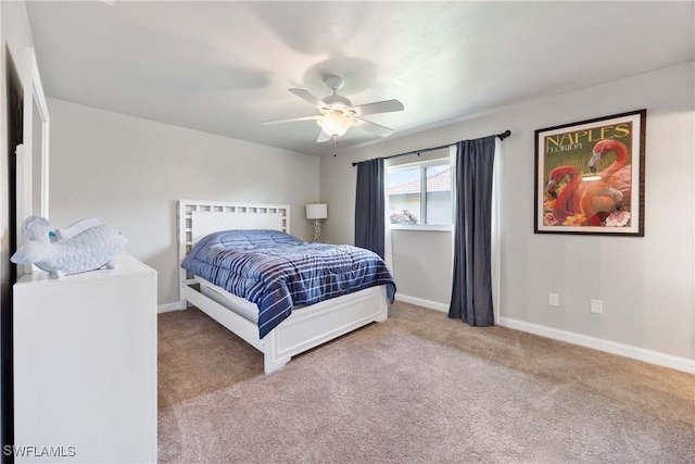 carpeted bedroom with ceiling fan and baseboards