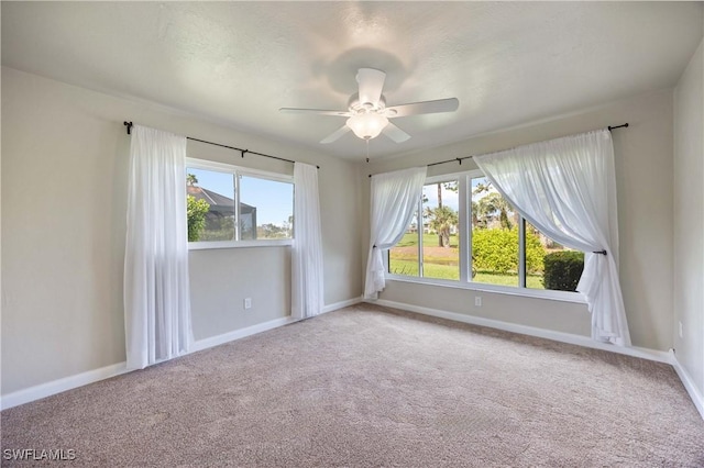 empty room with a ceiling fan, a textured ceiling, baseboards, and carpet flooring