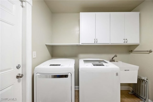 laundry room with a sink, cabinet space, and washer and dryer