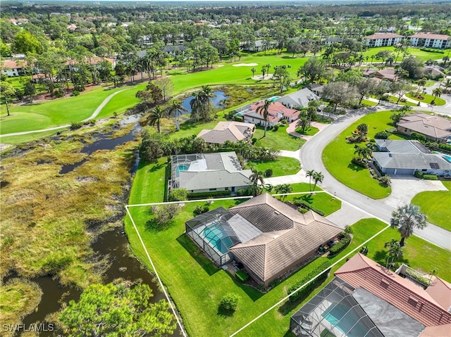 drone / aerial view featuring a residential view, view of golf course, and a water view