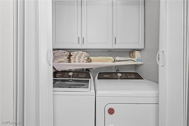 washroom with cabinets and washing machine and dryer