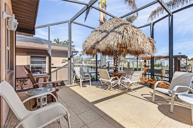 view of patio / terrace featuring a water view and a lanai