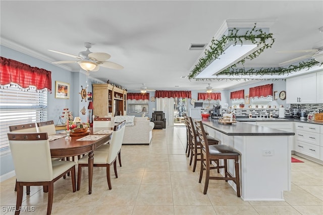 kitchen featuring white cabinetry, ceiling fan, crown molding, and light tile patterned flooring