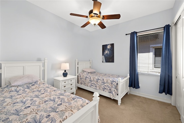 bedroom featuring a closet, light colored carpet, and ceiling fan