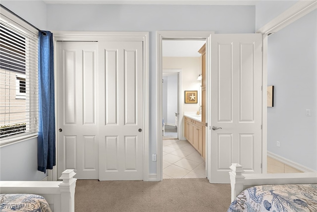 carpeted bedroom featuring a closet and ensuite bathroom