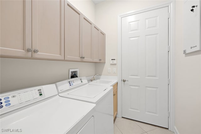 laundry room featuring cabinets, sink, light tile patterned floors, and washing machine and clothes dryer