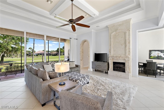 tiled living room with coffered ceiling, beamed ceiling, ceiling fan, crown molding, and a fireplace