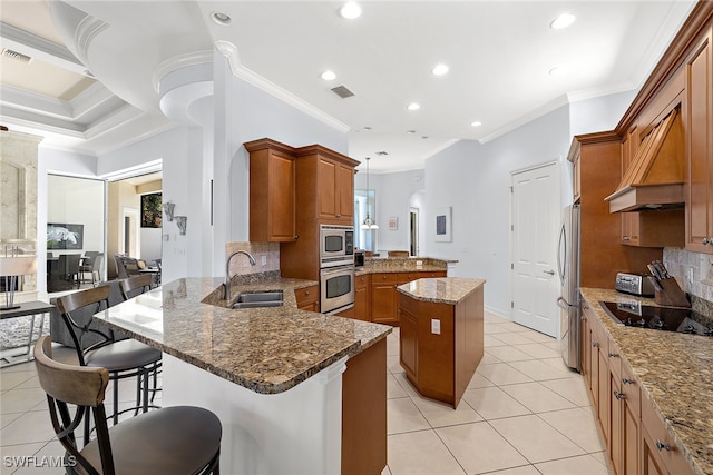 kitchen featuring stainless steel appliances, sink, kitchen peninsula, a kitchen bar, and backsplash