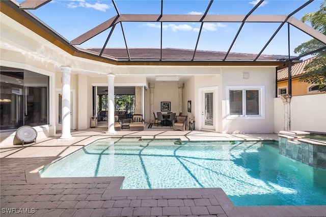 view of pool with a lanai, a patio, and an in ground hot tub