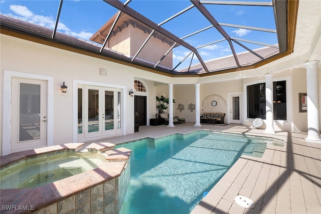 view of swimming pool featuring glass enclosure, an in ground hot tub, french doors, and a patio area