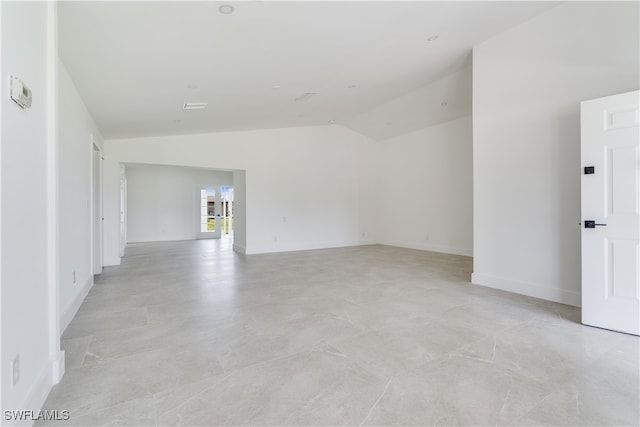 unfurnished room with lofted ceiling