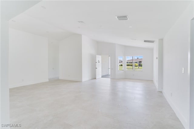 unfurnished room with vaulted ceiling