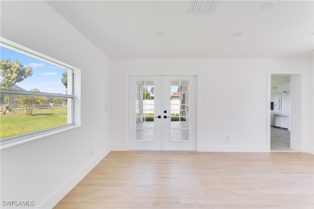 empty room with french doors and light wood-type flooring