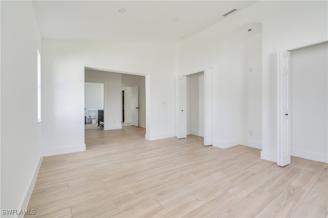 spare room with high vaulted ceiling and light hardwood / wood-style flooring