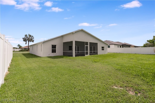 rear view of property with a sunroom and a yard