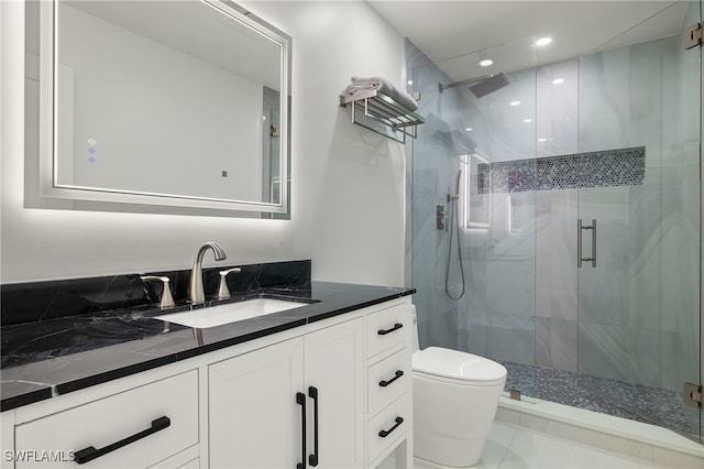 bathroom featuring vanity, an enclosed shower, and toilet