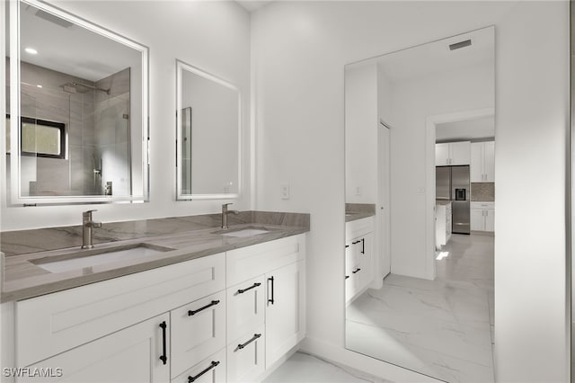 bathroom with vanity, decorative backsplash, and a tile shower