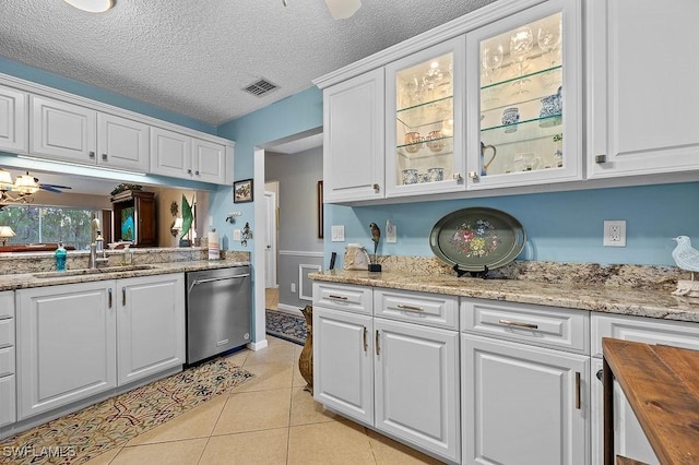 kitchen featuring light tile patterned floors, a sink, visible vents, white cabinetry, and dishwasher