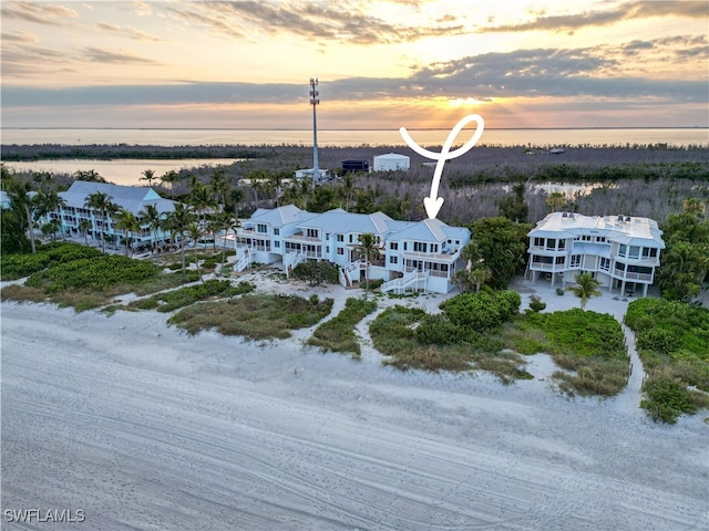 aerial view at dusk featuring a water view