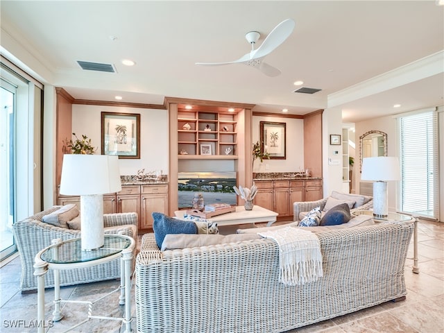 living room with a fireplace, a wealth of natural light, crown molding, and ceiling fan