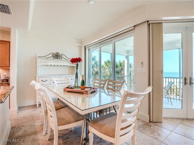 dining space with crown molding and french doors