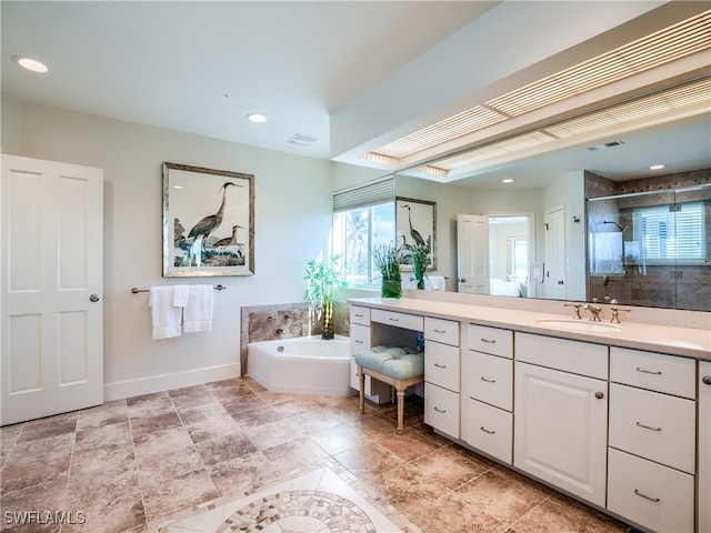 bathroom with separate shower and tub, plenty of natural light, and vanity