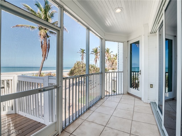 unfurnished sunroom featuring a water view and wooden ceiling