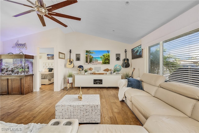 living room featuring ceiling fan, vaulted ceiling, and light wood-type flooring