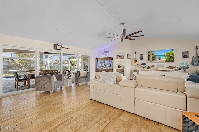 living room with ceiling fan, plenty of natural light, light hardwood / wood-style floors, and vaulted ceiling