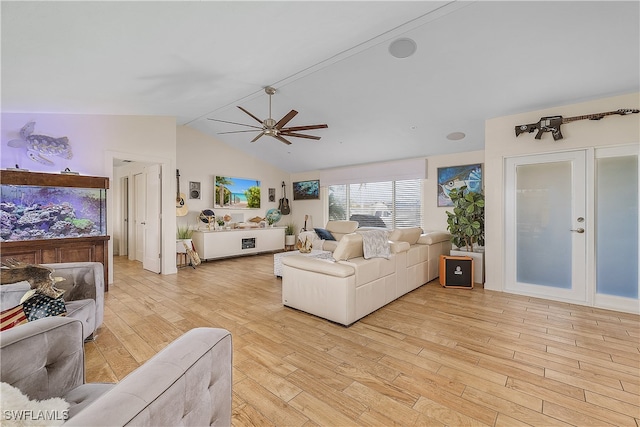 living room featuring ceiling fan, light hardwood / wood-style flooring, and vaulted ceiling